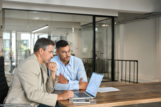 Two busy investors or traders, advisor and analyst investing in financial trade stock market analyzing chart forecast crypto strategy and money loss risks using laptop working in office. Copy space.