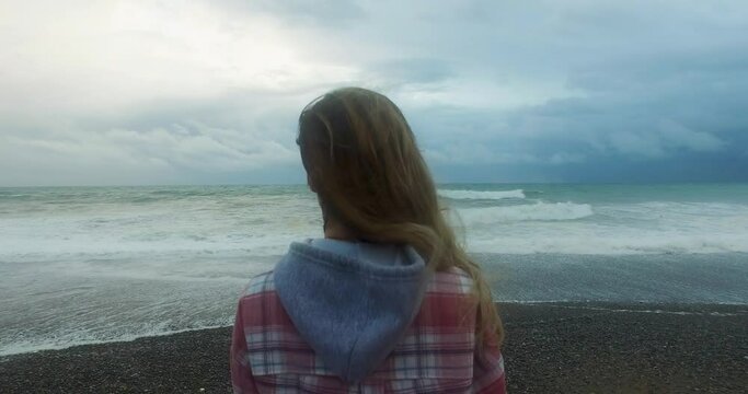 Woman, wind, and raging waves