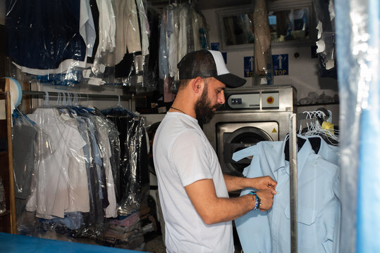 Man in Side View Buttoning Blue Shirt.