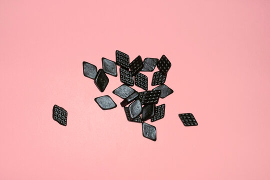 Black salty licorice / liquorice candy with hard direct flashlight