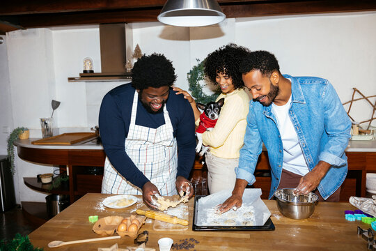 Smiling friends cooking in kitchen on Christmas time ugc