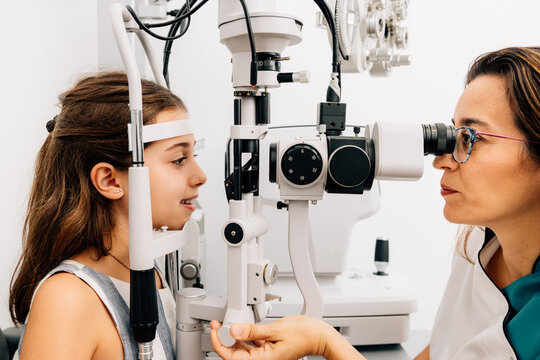 Professional woman ophthalmologist examining child eye