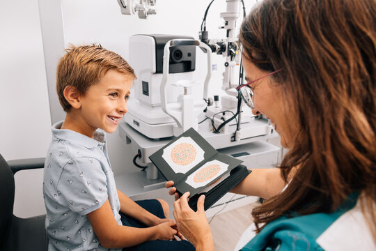 Optometrist doing color blindness test on boy