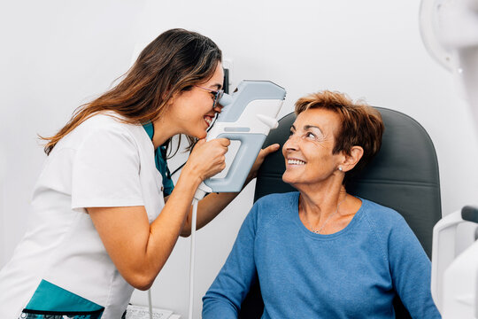 Happy mature woman patient and oculist doctor in clinic