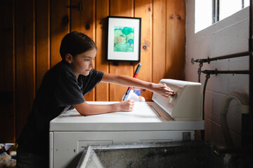 Tween loads washing machine with laundry