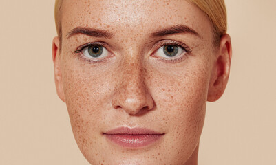 Close-up studio shot of a young female with freckles. Portrait of natural beauty woman with smooth...