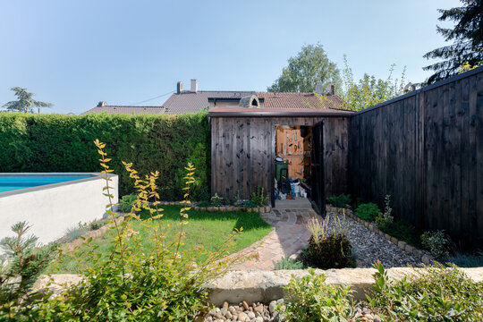 Storage room in backyard next to a swimming pool