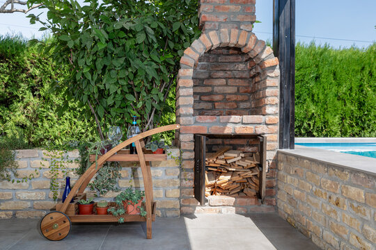 Drinks trolley and built BBQ grill in backyard next to a swimming pool