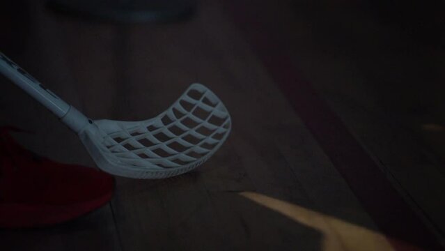 Valmiera, Latvia, March 10, 2024 - Close-up of a floorball stick and a player's shoe on the court, likely in a slow-motion shot during a game or practice.