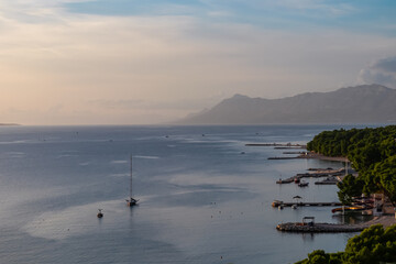 Silhouette of sailing boat with sunset view of Dalmatian archipelago seen from coastal town Makarska, Split-Dalmatia, Croatia, Europe. Coastline of Makarska Riviera, Adriatic Sea. Balkans in summer