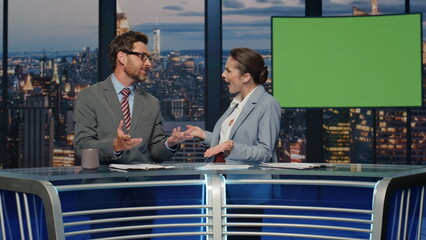 Couple anchors discussing mockup news at evening tv closeup. Presenters smiling