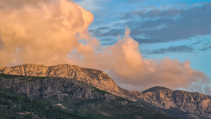 Scenic sunset view of cloud covered Biokovo mountains in majestic Dinaric Alps seen from Makarska,...