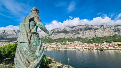 Statue of Saint Peter on peninsula overlooking coastal town Makarska, Split-Dalmatia, Croatia,...