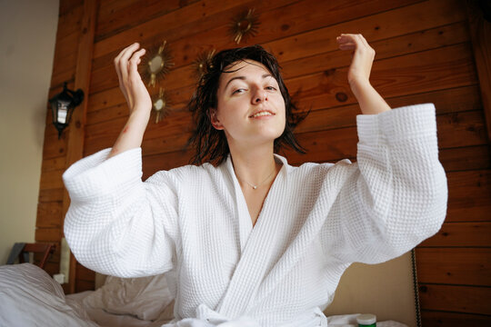 Woman with bathrobe in her bedroom having fun