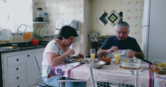 Senior couple sharing lunch together, authentically portraying life of an elderly husband and wife in a modest home in South America