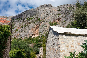 Fototapeta na wymiar Scenic view of ancient fortress build into massive rock formation in village Kotisina near Makarska, Split-Dalmatia, Croatia, Europe. Hiking in Biokovo nature park in mountain of Dinaric Alps, Balkan