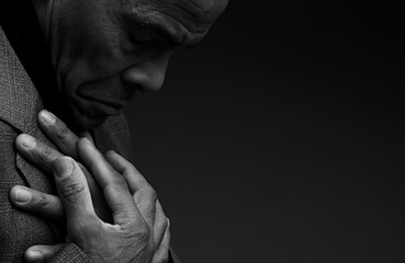 man praying to god with hands together worshiping God Caribbean man praying with people stock image stock photo	