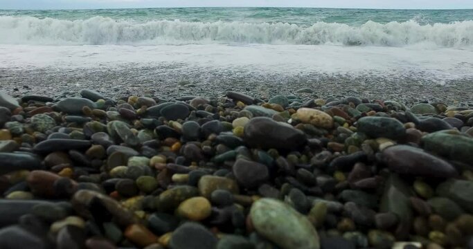 Sea stones lie along the shoreline, with the vast expanse of the ocean stretching out behind them