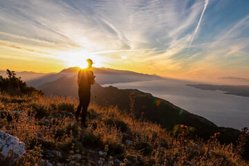 Hiker man with scenic sunrise view from top of mount Kula near Omis, Dinara mountains,...