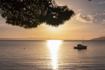 Fototapeta na wymiar Silhouette of luxury boat during sunset at Dalmatian archipelago seen from coastal town Makarska, Split-Dalmatia, Croatia, Europe. Coastline of Makarska Riviera, Adriatic Sea. Balkans in summer