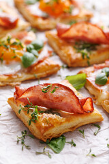 Puff pastry ham and egg mini tarts, focus on the middle ham tart, close up view. Delicious breakfast or Easter snack