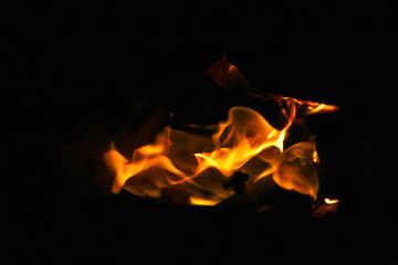 Orange flame fire on black background. Dramatic flames flickering against the darkness. Fire and...