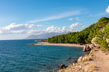 Idyllic stone beach Plaza Ramova in coastal town Krvavica, Dalmatia, South Croatia, Europe. Scenic view of majestic Makarska Riviera in Adriatic Mediterranean Sea. Mountains of Biokovo nature reserve