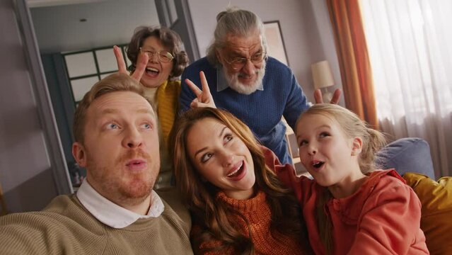 Father taking selfie while family members making bunny ears