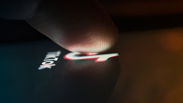 Dobrich, Bulgaria - March 15 2024: macro shot of a person using TikTok social media platform on a mobile phone. Illustrative editorial photo of a person using TikTok.