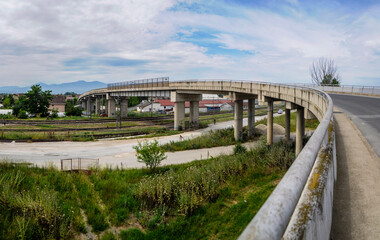 Fototapeta premium An overpass (bridge) built of concrete pillars and asphalt passes over the track through which the high-speed trains pass.