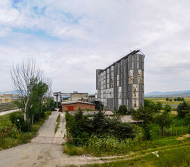 Fototapeta na wymiar Old grain silos built alongside a highway and railroad.