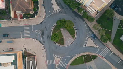 Urban circular traffic top view at cozy european town district. Green roundabout