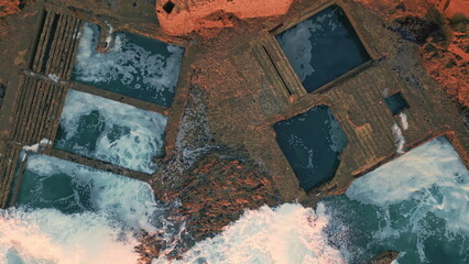 Rough coastal stones washed by stormy foamy ocean top view. Beautiful waves 