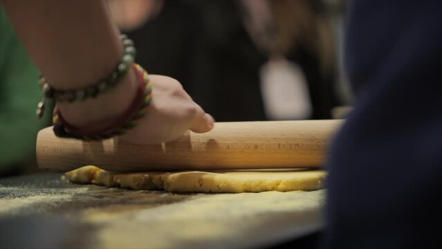 Cook working his dough with a rolling pin
