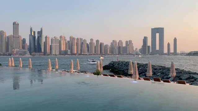 Dubai Jumeirah beach with marina skyscrapers in UAE. Luxurious sandy beach. Boat