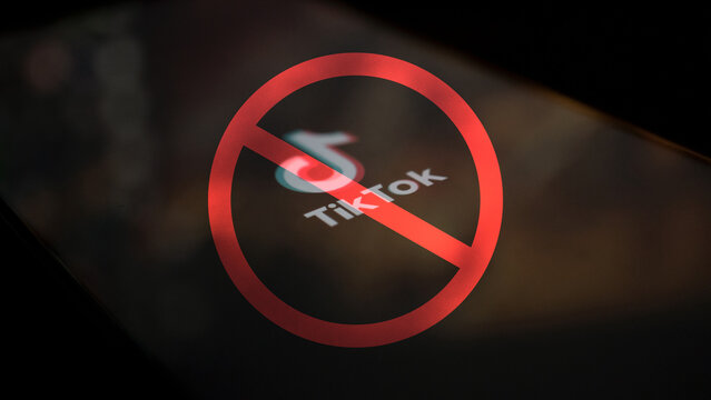 Dobrich, Bulgaria - March 15 2024: TikTok logo crossed out with red ban sign. Prohibited and banned social media app. Illustrative editorial concept of TikTok being banned.