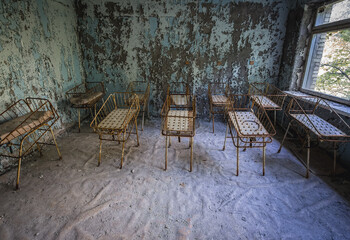 Fototapeta na wymiar Cribs in maternity ward of Hospital MsCh-126 in Pripyat ghost city in Chernobyl Exclusion Zone, Ukraine