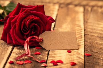 red rose and old book on wooden background with copyspace and hearts