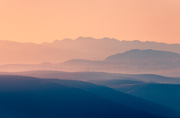 Sunset silhouette of Siete Picos and wind turbines