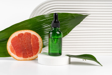 A green dropper bottle of citrus-infused oil set against a large leaf and sliced grapefruit, evoking a refreshing and natural vibe