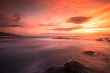 Dramatic crimson skies blaze above the soft mist of the sea at Punta del Hidalgo, capturing nature's fiery artwork