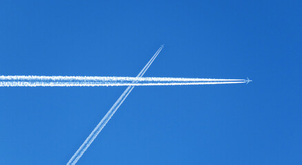 contrails chemtrails airplane smoke trail gases on blue sky background - obrazy, fototapety, plakaty