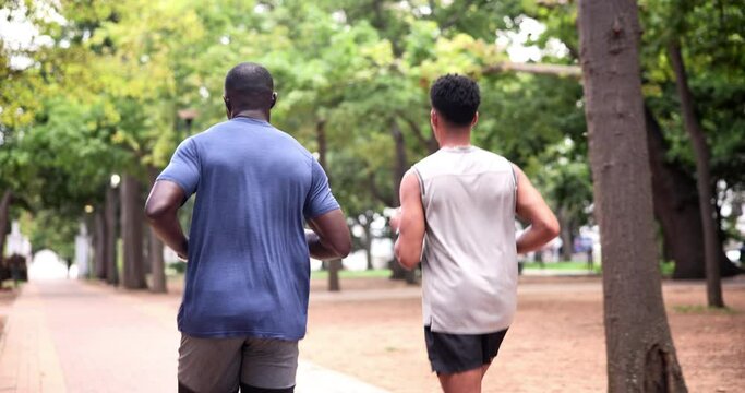 Fitness, running and man with personal trainer in park for outdoor morning workout in woods. Health, wellness and friends in nature together for muscle exercise, marathon and men training from back.