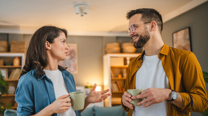 Couple husband wife stand at home with cup of coffee talk happy smile