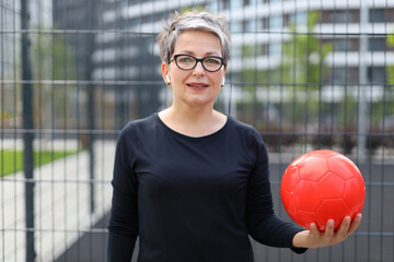 A pretty middle-aged woman enjoys outdoor fitness training, embracing a healthy lifestyle with...