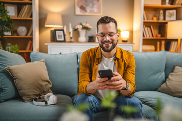 One man with headphones at home listen music online happy smile