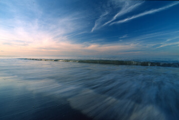 sunset over the sea, Retreating waves over beach with with a motion blur effect obtained using a...