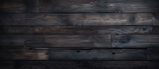 A close up of a dark hardwood flooring with a blurred background, showcasing a brown rectangle pattern in the darkness