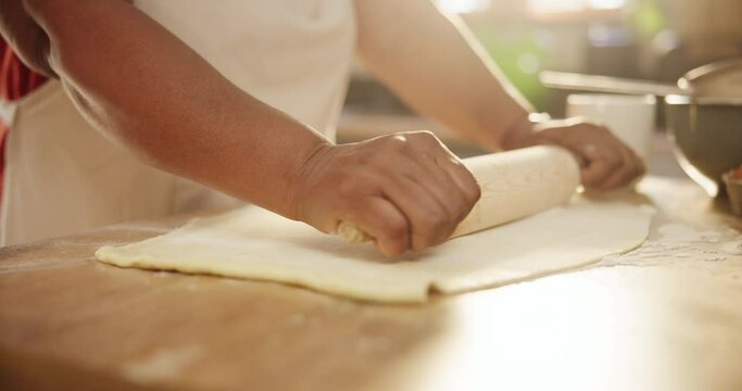 Closeup, hands and dough for cooking in kitchen with rolling pin, wheat or meal prep for pizza or bread in home. Person, baking process or ingredients with pastry for cake, handmade cookies and snack