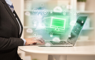 Hands working on laptop with digital icons